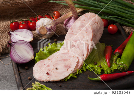 chicken ham on a wooden board decorated with fresh vegetables chicken ham on a wooden board decorated with fresh vegetables 92103043