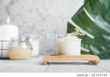 Natural loofah scrubber on podium in bathroom. Zero waste in life. Relaxation spa concept, candles, beauty.. 92103538