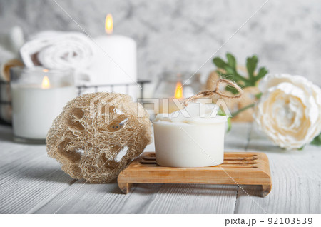 Natural loofah scrubber on podium in bathroom. Zero waste in life. Relaxation spa concept, candles, beauty.. Natural loofah scrubber on podium in bathroom. Zero waste in life. Relaxation spa concept, candles, beauty.. 92103539