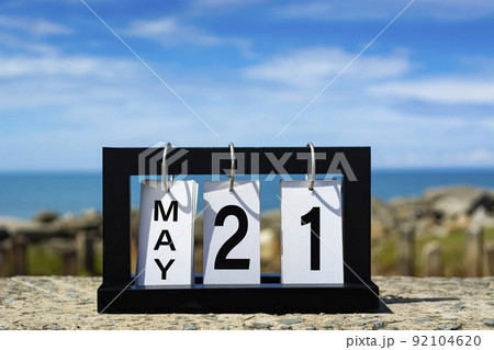 May 21 calendar date text on wooden frame with blurred background of ocean. May 21 calendar date text on wooden frame with blurred background of ocean. 92104620