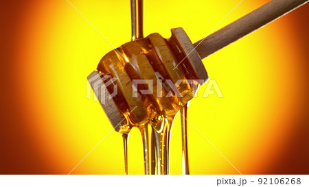 Honey dripping from wooden dripper. Honey dripping from wooden dripper. 92106268