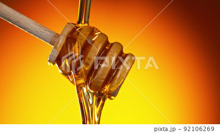 Honey dripping from wooden dripper. Honey dripping from wooden dripper. 92106269