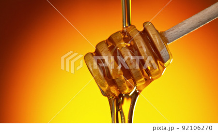 Honey dripping from wooden dripper. Honey dripping from wooden dripper. 92106270
