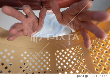 A man puts his hands inside a brown pet carrier basket. Adult male wants to get a cat or puppy out of a plastic carrier. Inside view. Selective focus. A man puts his hands inside a brown pet carrier basket. Adult male wants to get a cat or puppy out of a plastic carrier. Inside view. Selective focus. 92106437