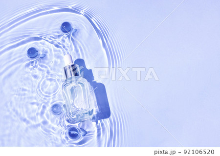 Mockup of cosmetic glass blue bottle with pipette and serum on water surface with waves 92106520