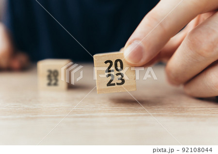 The concept of the new year 2023. Person holding a cube with numbers 92108044