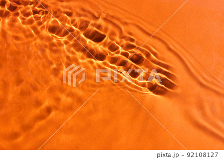 Clear water surface texture with waves. Orange background. Hot summer concept. Clear water surface texture with waves. Orange background. Hot summer concept. 92108127