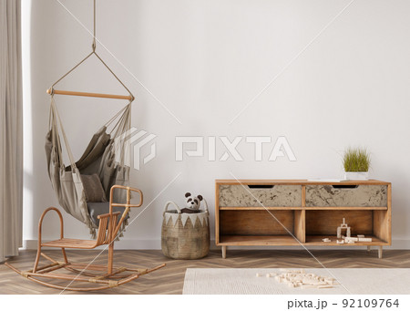 Empty wall in modern child room. Mock up interior in boho style. Copy space for your picture or poster. Wooden sideboard, rattan basket, hanging armchair, toys. Cozy room for kids. 3D rendering. 92109764
