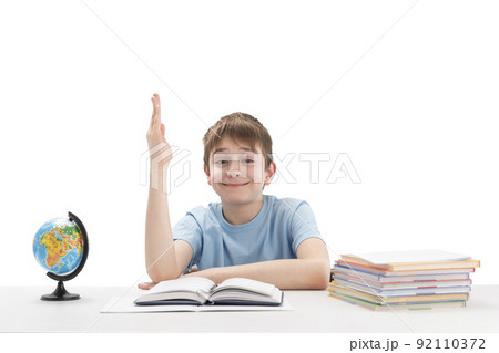 Clever boy raised his hand high in class. Portrait of schoolboy with notebooks and textbook. White background. Excellent student. Clever boy raised his hand high in class. Portrait of schoolboy with notebooks and textbook. White background. Excellent student. 92110372