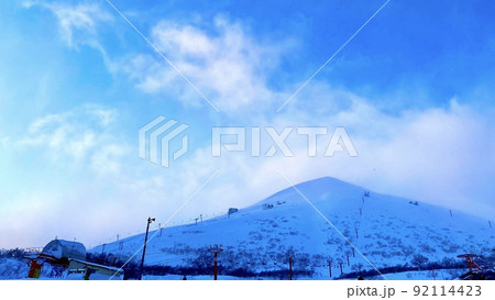 積雪したニセコアンヌプリ山と雲がかかる夕方の空 92114423