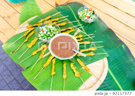 grilled Satay pork, Thailand traditional popular food stick with wood strick, cooked ready to eat with specific sauce beside. grilled Satay pork, Thailand traditional popular food stick with wood strick, cooked ready to eat with specific sauce beside. 92117377