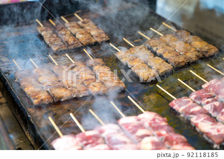 Grilled square beef sticks (Japanese) are arranged on the big pan plate with smoke around. Grilled square beef sticks (Japanese) are arranged on the big pan plate with smoke around. 92118185
