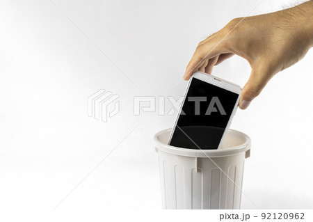 ゴミ箱にスマートフォンを捨てる男性の手。デジタルデトックスのイメージ 92120962