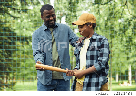 Dad teaching his son to play baseball 92121433