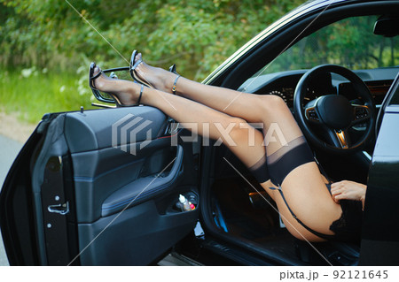 Female legs in stockings the opened door of the car 92121645