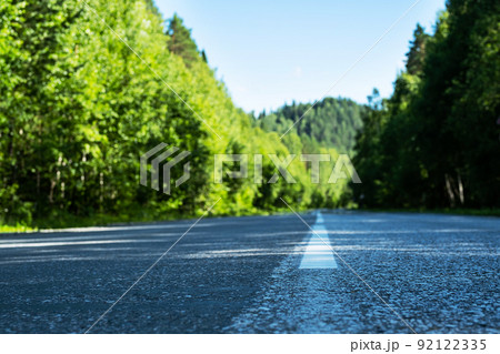 Empty road. Speedway without cars in mountains amid pine forests. Adventure or road trip background. 92122335