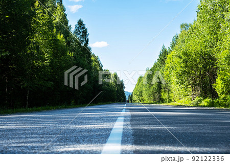 Empty road. Speedway without cars in mountains amid pine forests. Adventure or road trip background. 92122336