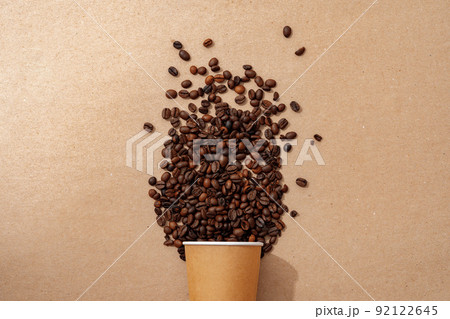 Cup of coffee with coffee beans on paper background. Top view Cup of coffee with coffee beans on paper background. Top view 92122645