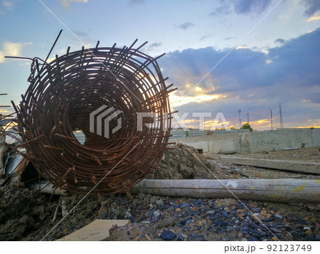 Rusted steel rolls in construction projects. Steel and bamboo on clay and stone piles 92123749