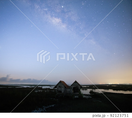 Milky Way early morning before sunrise , old abandoned house, red roof on open field 92123751