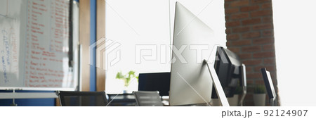 Empty office, computers on desks, light room for company employees 92124907