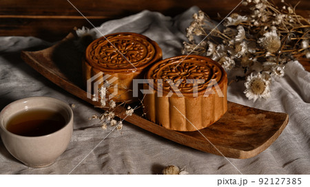 Chinese mooncakes with cup of tea and decorating with dried flower on wooden table for Mid Autumn festival 92127385
