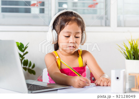 Asian child girl studying video conference distant education at home Asian child girl studying video conference distant education at home 92128049