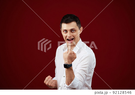 amazed man celebrating victory on red background. amazed man celebrating victory on red background. 92128546