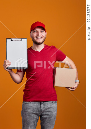 Delivery man holding clipboard and empty cardboard box Delivery man holding clipboard and empty cardboard box 92128577