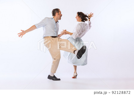 Portrait of young stylish couple, man and woman, dancing isolated over white studio background. Classic dance styles 92128872