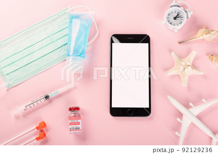 Top view model plane, medical face mask, coronavirus vaccine and smartphone Top view model plane, medical face mask, coronavirus vaccine and smartphone 92129236