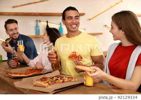 Group of friends having fun party with delicious pizza in cafe Group of friends having fun party with delicious pizza in cafe 92129334