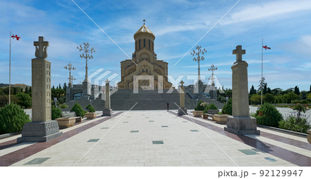 Holy Trinity Cathedral of Tbilisi , Georgia external daylight view  showing unique architecture of the cathedral with people walking on the stairs and clouds in the sky    92129947