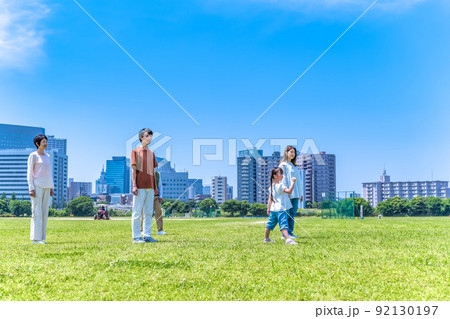 公園を駆けっこをする家族三世代 92130197