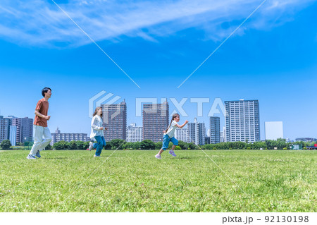 公園を駆けっこをする家族 92130198
