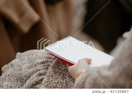 A woman's writing hand.A woman writes in a notebook close-up A woman's writing hand.A woman writes in a notebook close-up 92130867