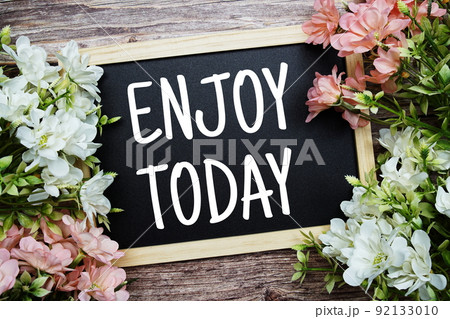 Enjoy Today typography text written on wooden blackboard with flower bouquet decorate on wooden background 92133010