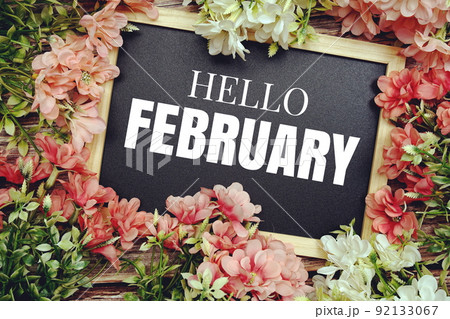 Hello February typography text written on wooden blackboard with flower bouquet decorate on wooden background 92133067