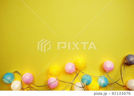 LED cotton ball garland decorate on yellow background LED cotton ball garland decorate on yellow background 92133076