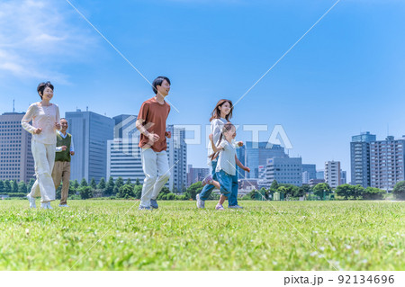 公園を駆けっこをする家族三世代 公園を駆けっこをする家族三世代 92134696