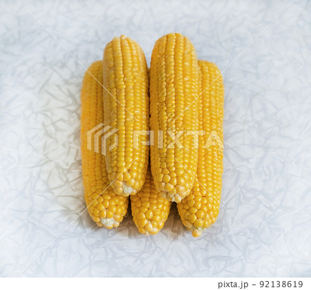 pile of corn cobs on a light background, vegetables stacked pile 92138619