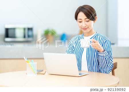 リビングでテレワークをするミドル女性 リビングでテレワークをするミドル女性 92139092