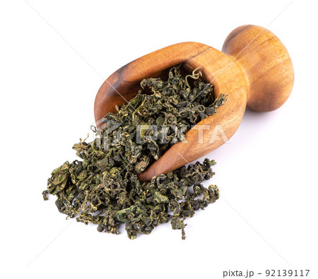 Dry gynostemma pentaphyllum leaf in wooden scoop, isolated on white blackground. Jiaogulan or Miracle grass. Chinese herbal tea. 92139117