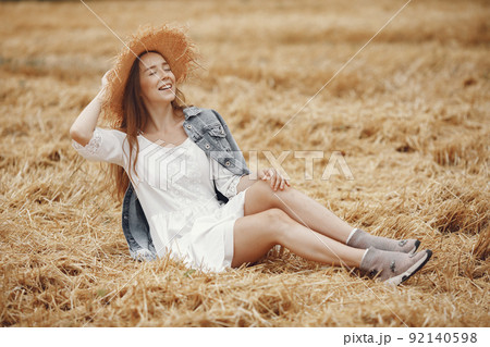 Woman in a summer field. Lady in a white dress. Girl on a sunset background. 92140598