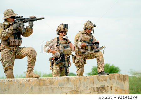 Military or soldier team with gun stay on concrete wall and prepare for battle with enemy in field Military or soldier team with gun stay on concrete wall and prepare for battle with enemy in field 92141274