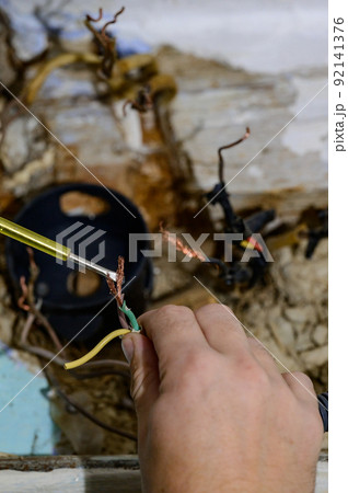 Old electrical wiring in the house, wooden walls in the house, replacement of electrical cables. Old electrical wiring in the house, wooden walls in the house, replacement of electrical cables. 92141376