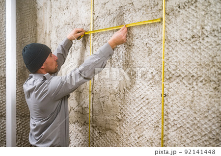 measuring the distance between the guide metal beacons, metal beacons attached to a wooden wall. measuring the distance between the guide metal beacons, metal beacons attached to a wooden wall. 92141448