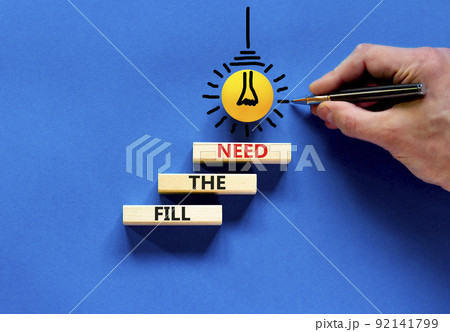 Fill the need symbol. Concept words Fill the need on wooden blocks on a beautiful blue table blue background. Businessman hand. Business, finacial and fill the need concept. Copy space. 92141799