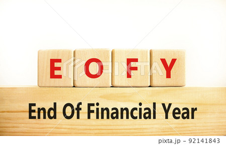 EOFY end of financial year symbol. Concept words EOFY end of financial year on wooden blocks on beautiful white background. Businessman hand. Business and EOFY end of financial year concept. 92141843