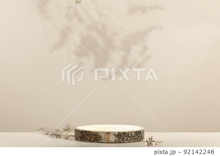Wood slice podium and dry flowers on beige background for cosmetic product mockup 92142246